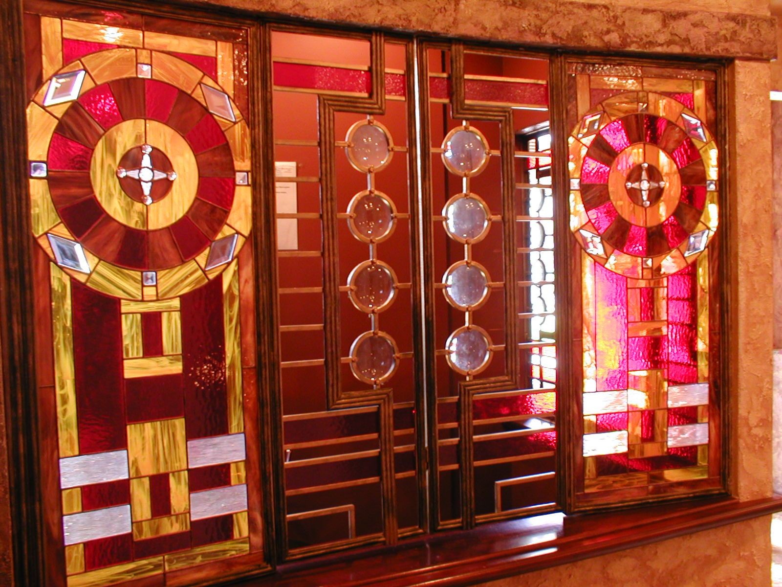 Ornate stained glass windows with geometric patterns in red and gold hues.